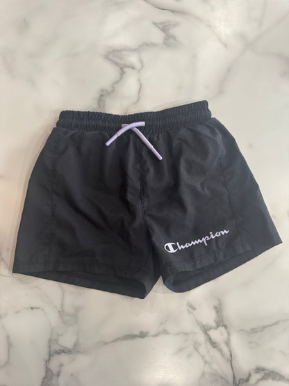 Black shorts with a brand logo on a marble surface